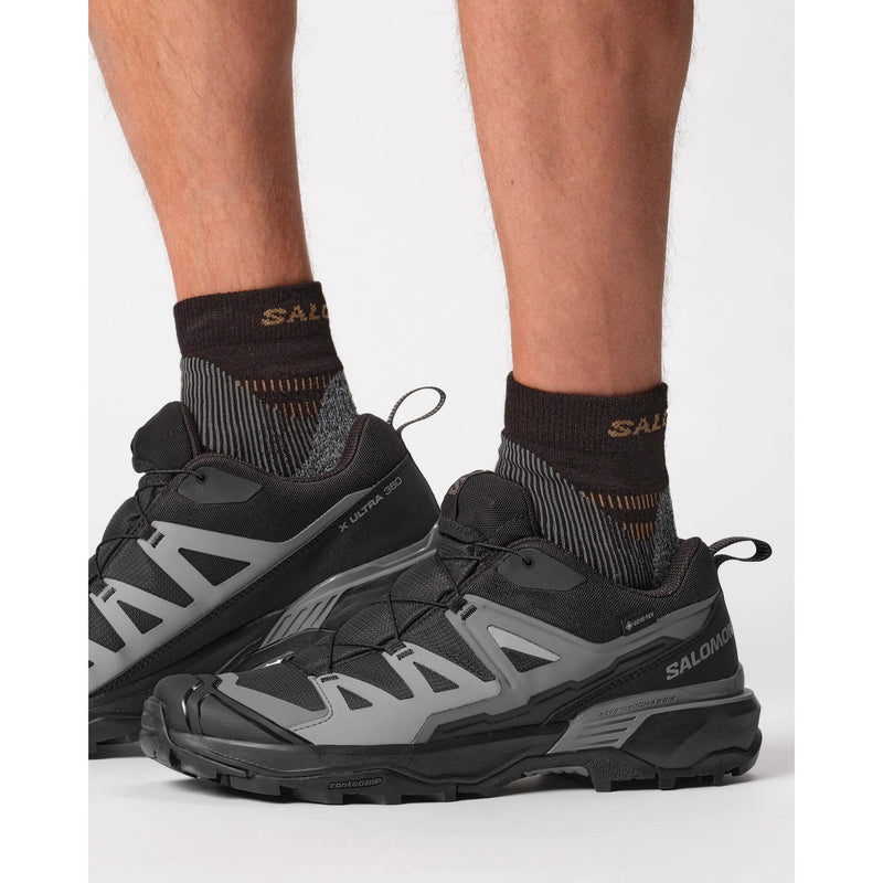 A black and gray Salomon X Ultra 360 trail running shoe shown on a model against a plain white background.