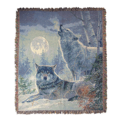 Throw blanket featuring a wolf resting in the snow while another howls at the full moon against a white background. 