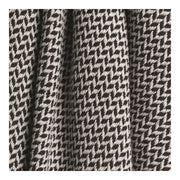 Close up of a black and white colored throw blanket with a wavy design.