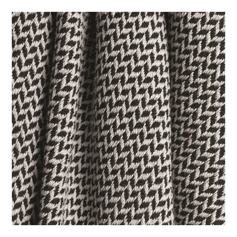 Close up of a black and white colored throw blanket with a wavy design.