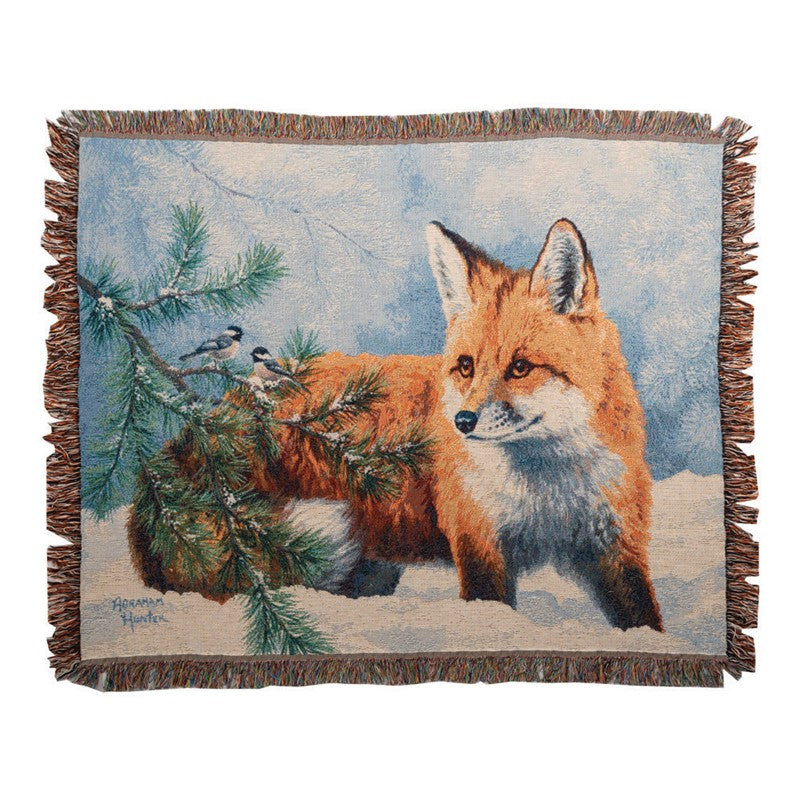 Woven blanket with a fox and birds design on a snowy background