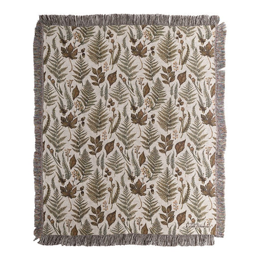 Throw blanket featuring various leaves and plants against a white background. 