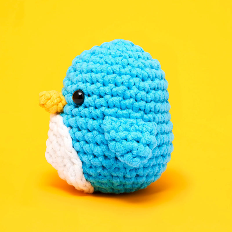Blue knitted bird toy on a yellow background