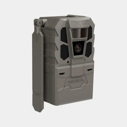 A rugged gray tactical trail camera with a side-mounted flip-out antenna, featuring a prominent front lens and the brand name 'REVEAL' embossed on the lower front, set against a plain light gray background.