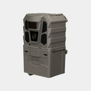 A rugged gray and black trail camera with a front lens, flash window, and side button, shown on a plain light gray background. The brand name 'REVEAL' is embossed on the lower front.