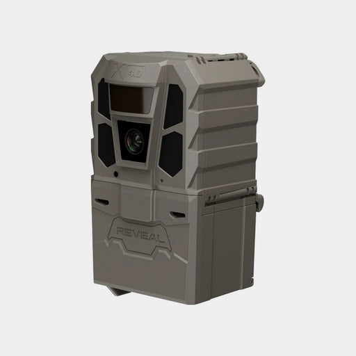 A rugged gray and black trail camera with a front lens, flash window, and side button, shown on a plain light gray background. The brand name 'REVEAL' is embossed on the lower front.