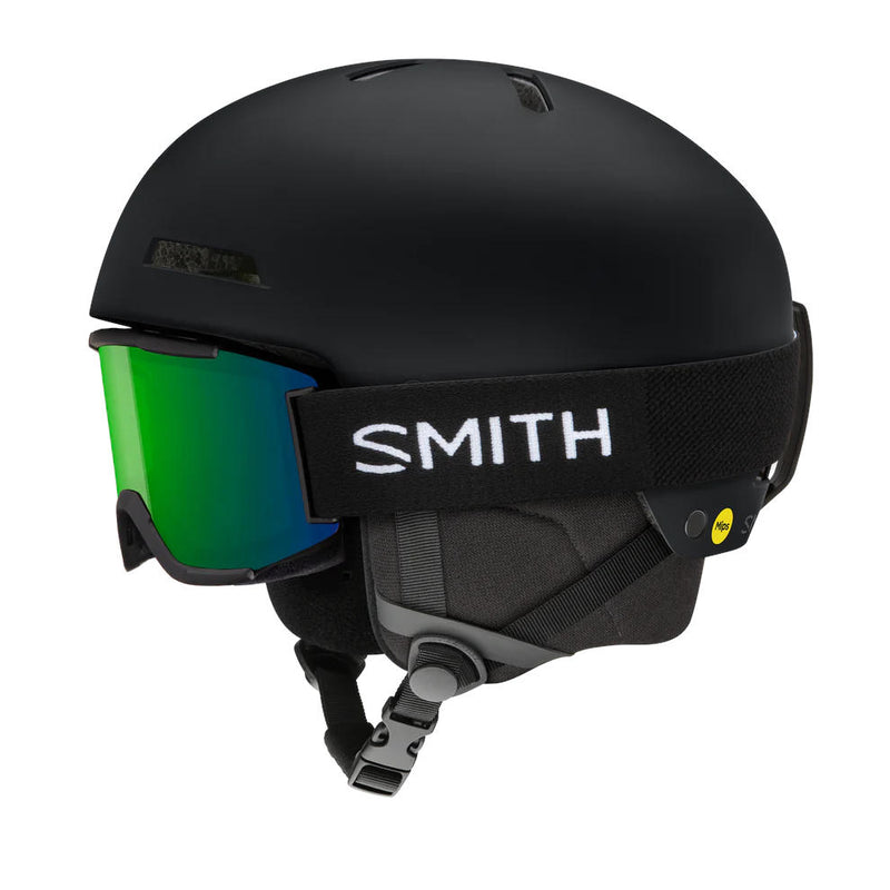 Black ski helmet with green goggles on a white background