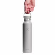 Silver water bottle held by a hand on a white background