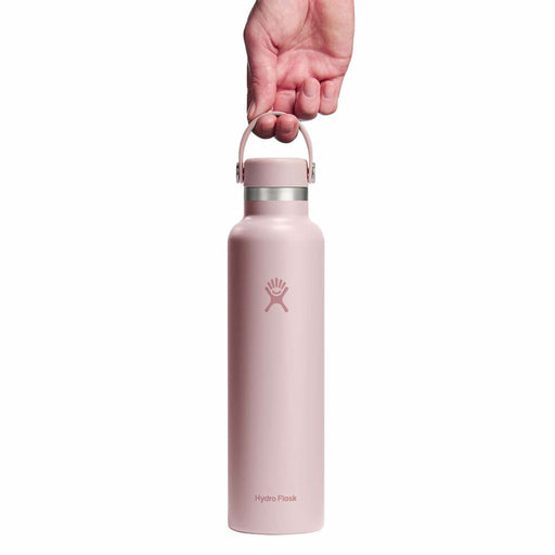 A hand holding the handle of a Hydro Flask insulated water bottle against a solid white background.