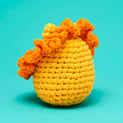 Crocheted yellow and orange lion on a teal background