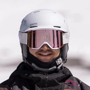 Person wearing a white Smith helmet and goggles with a blurred background