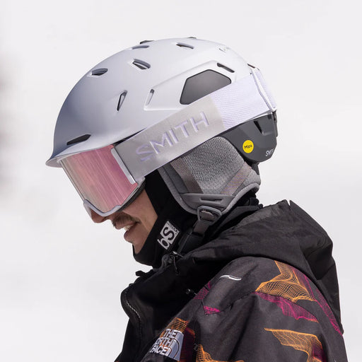 Person wearing a white Smith helmet with a pink visor against a light gray background