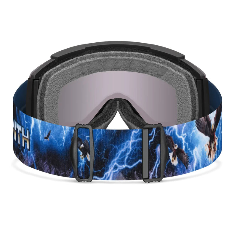 Goggles with a blue and black eagle design on the strap against a white background