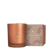 Bronze-colored candle with Thymes branding next to its packaging on a white background