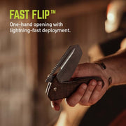 Folding knife with 'Fast Flip' feature held in a hand, blurred background