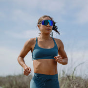 A person running outside wearing a pair of sunglasses with blue lenses