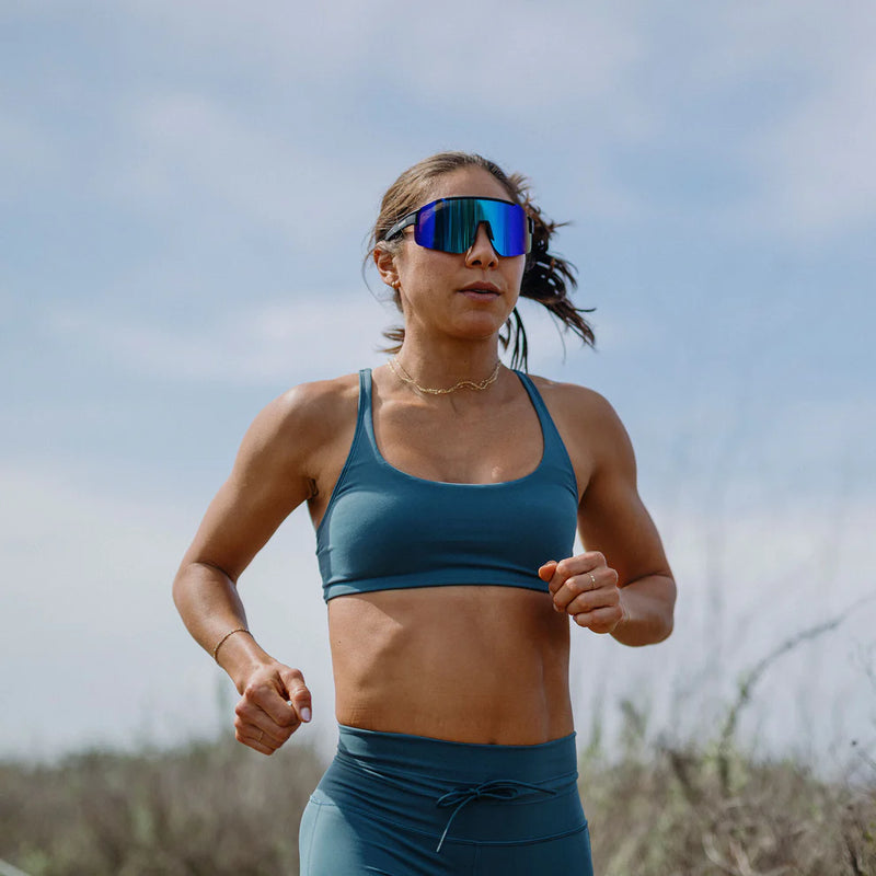 A person running outside wearing a pair of sunglasses with blue lenses