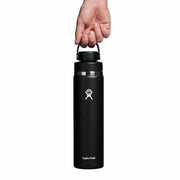 Black Hydro Flask water bottle held by a hand on a white background