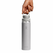 Gray water bottle with a hand holding it on a white background
