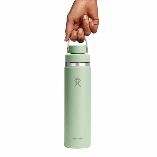 Light green water bottle with silver cap held by a hand on a white background