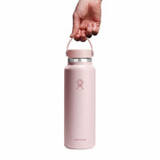 Pink Hydro Flask water bottle held by a hand on a white background