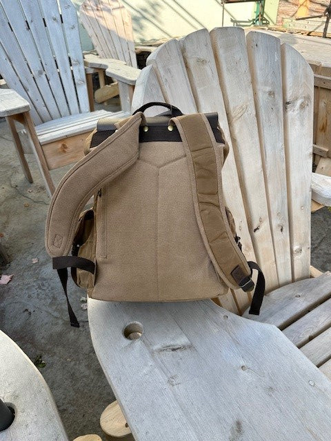 Tan backpack on a wooden chair outdoors