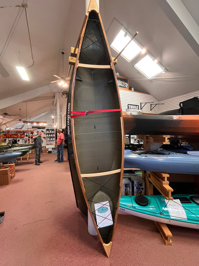 Slipstream Wee Lassie Canoe with an interior patched area on display in a store with other kayaks in the background