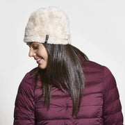 Woman looking to the side wearing a white fur beanie against a white background. 